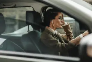 A woman driving her car while wearing headphones.