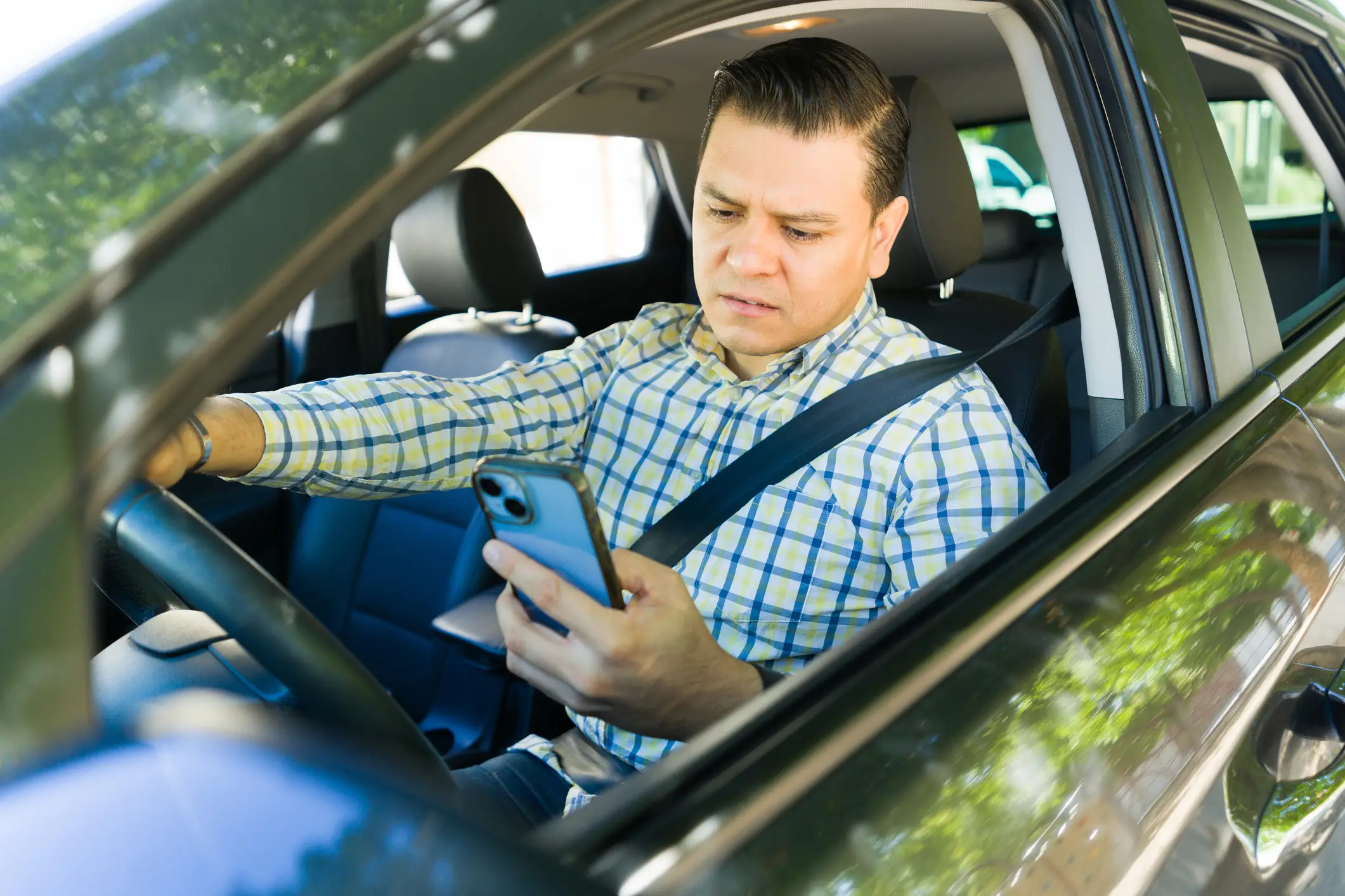A rideshare driver looking at his phone.