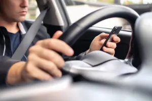 A rideshare driver on their phone while driving.