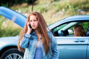 A woman on the phone calling for help for a car accident.