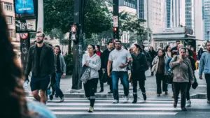A group of people walking on a sidewalk.
