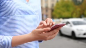 Woman on her phone requesting a rideshare driver.