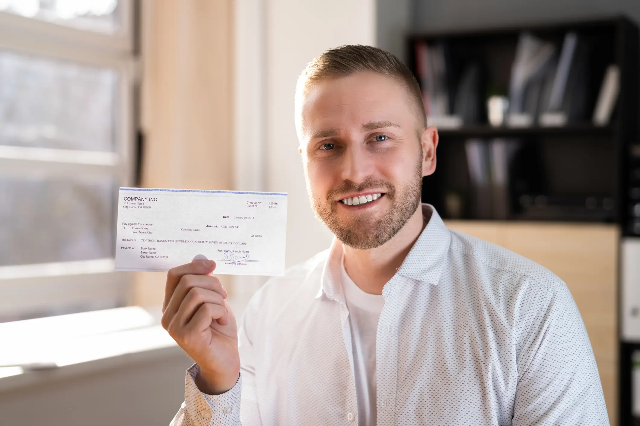 A man holding up a check.