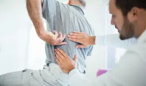 An old man with a back injury getting checked out by a doctor.