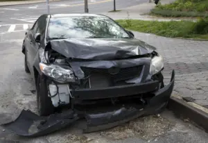 A black car with a broken front bumper.