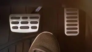 A gas pedal and break pedal with a foot in between.