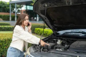 A young woman on the phone describing a problem with her car engine.