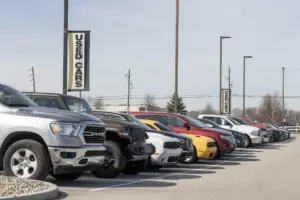 A car dealership lot with a row of cars.