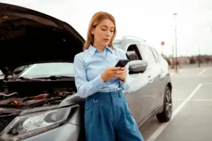 A woman on her phone after finding out her broken is a lemon.