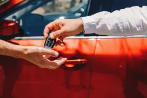 A person handing off car keys to another person.