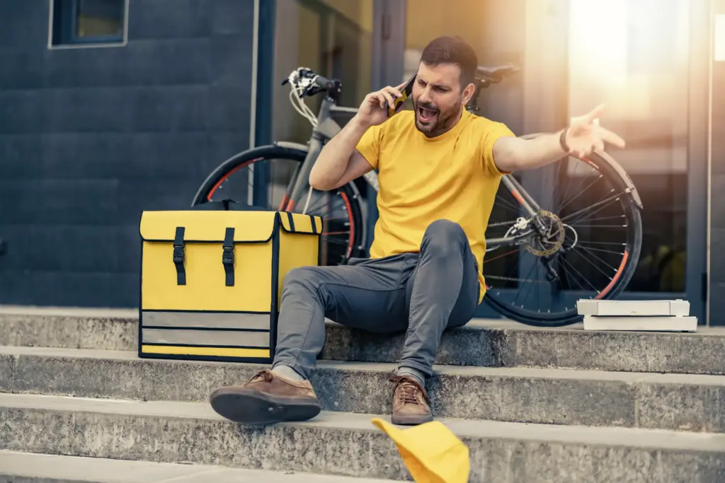 An angry food delivery biker on the phone.