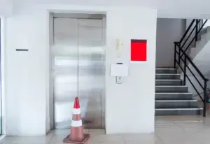 A broken elevator with a cone in front. 
