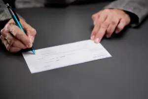 A person about to sign a check.