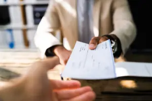 A man handing a person a check.