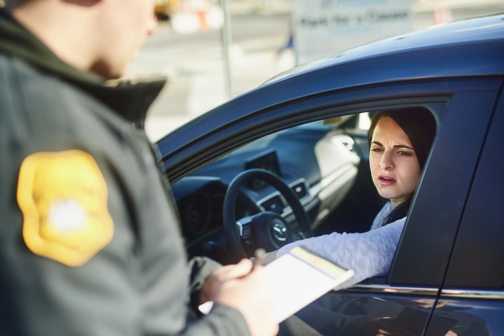 A police officer writing a ticket for a driver.