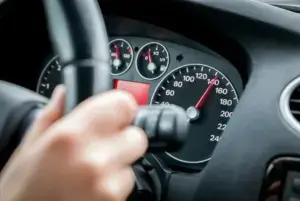 A driver speeding, showcasing a high odometer.