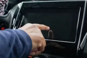 A person tapping the radio screen but it is pitch black.