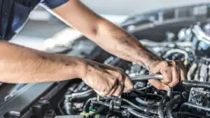 A man touching up a car engine.