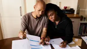 A sad couple looking at their bills.