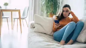 A woman looking at her phone in confusion.