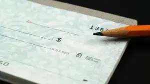 A close up of a check and a pencil.