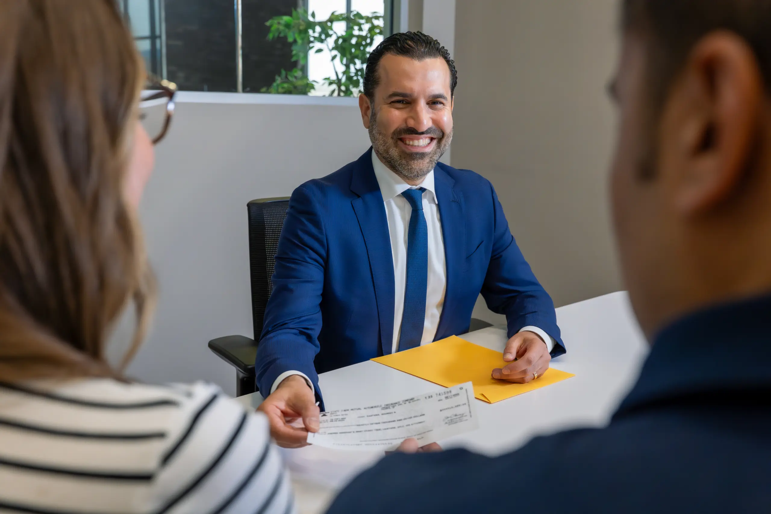 Neama Rahmani handing his clients a check.
