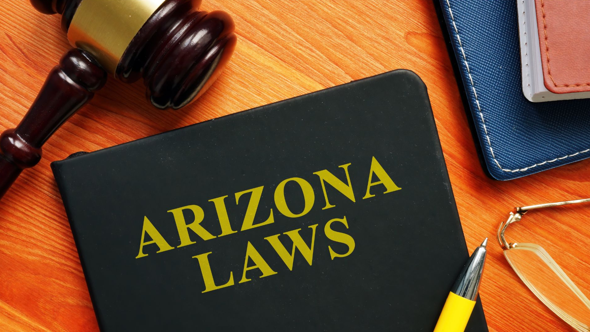 A book titled "Arizona Laws" with a gavel and books next to it.