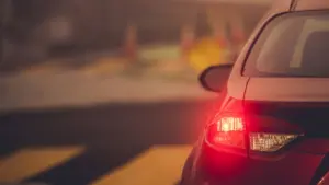 A red car stopped at a intersection. 