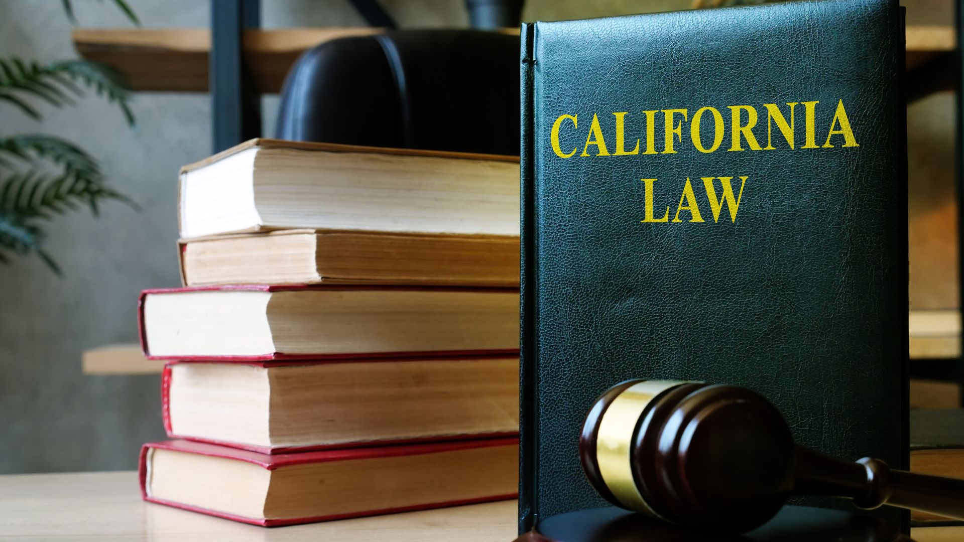 A stack of books and a gavel next to a book titled " California Law".